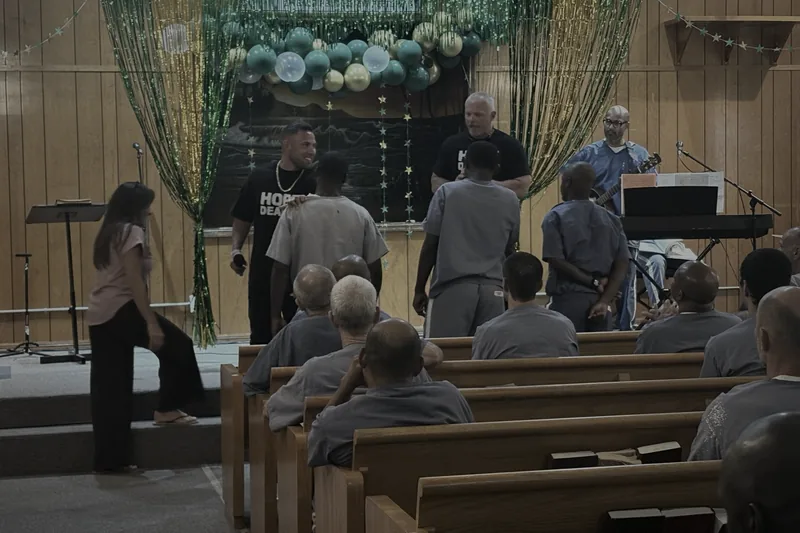 Frank Ortega on the prison chapel stage with inmates during a Hope Dealer service
