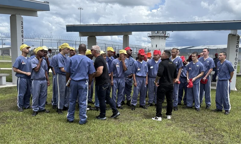 Ministry team praying with a circle of young men in a prison yard