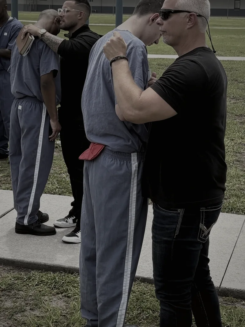 Ministry team praying one-on-one with inmates on the prison yard at Suwannee Correctional
